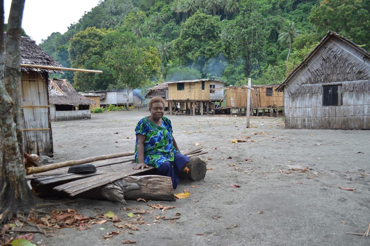 A villager taking a break from preparing the evening meal in one of a string of villages that are on the front lines of the mining project. (Credit: Mike Casey) 
